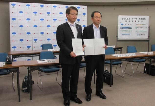 調印した包括的政策連携協定書を掲げる谷畑市長と、こなんウルトラパワー株式会社の芦刈社長の写真