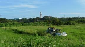 津波に呑み込まれた富岡町の防災車が草原の中にある写真