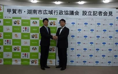 甲賀市長と湖南市長が設立記者会見にて握手をしている写真